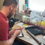 Photo of a man working on a product at a work bench